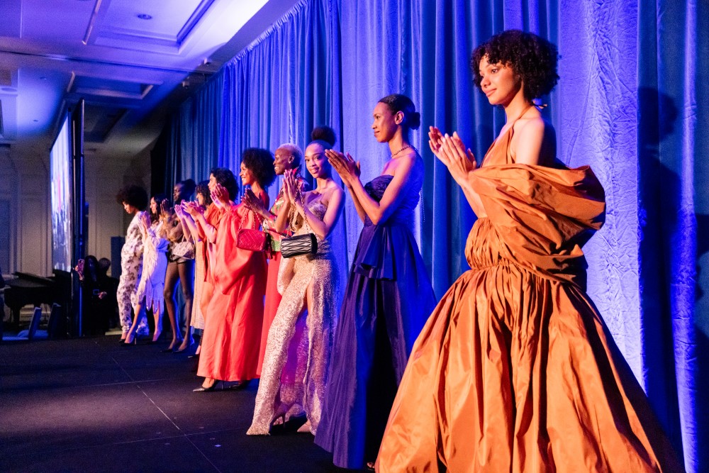 Models applaud Linda Johnson Rice following surprise fashion show.